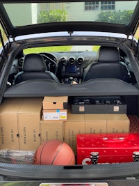 the trunk of a car is full of boxes and a basketball