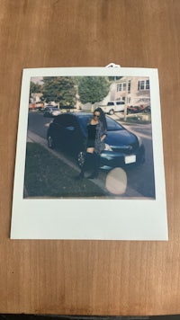 a photo of a person standing next to a car