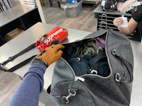 a person is opening a duffel bag in a store