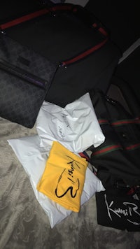 gucci luggage, bags, and other items on a bed