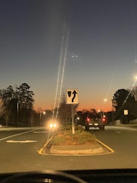 a car driving down a street at dusk