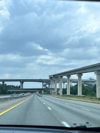 a car driving down a highway with a bridge over it