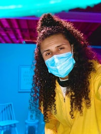 a woman wearing a surgical mask in a blue room