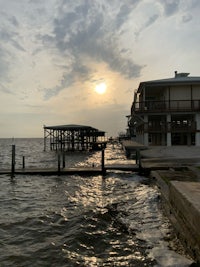 a house on the water with a dock in the background