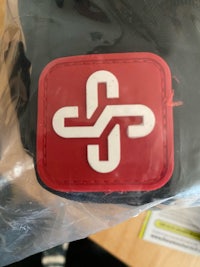 a patch with a red and white logo on it