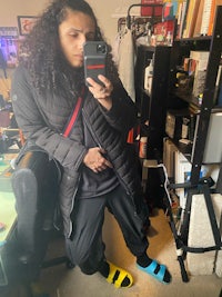 a person with curly hair taking a selfie in a room