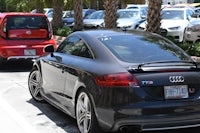 a black audi tt parked in a parking lot